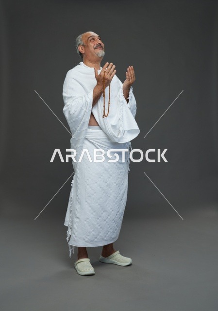 رجل سعودي بملابس الإحرام يدعو في الاستوديو