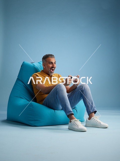 رجل سعودي يلعب ألعاب الفيديو على كرسي بين باق