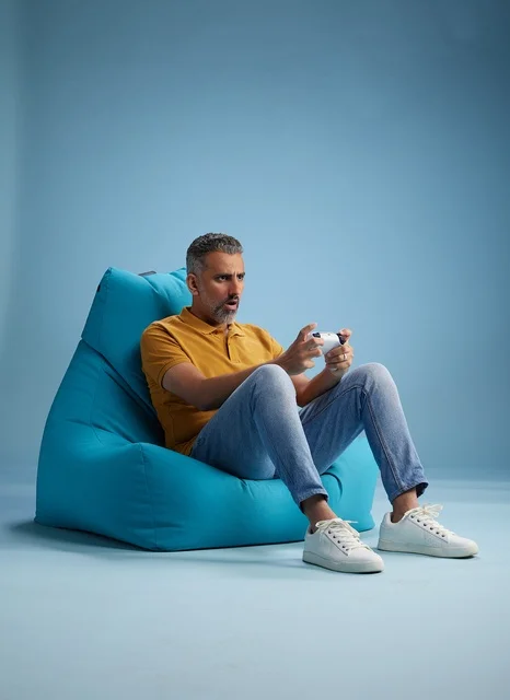 رجل سعودي يلعب ألعاب الفيديو على كرسي بين باق