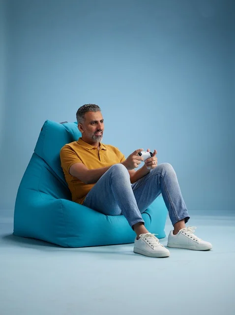 رجل سعودي يلعب ألعاب الفيديو على كرسي بين باج