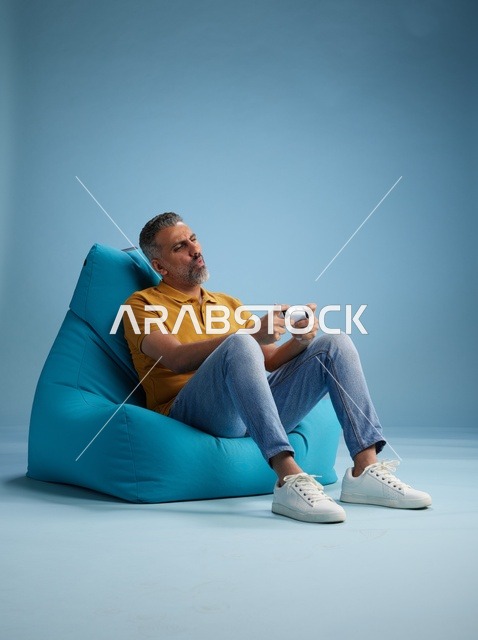 رجل سعودي يلعب ألعاب الفيديو على كرسي بين باق