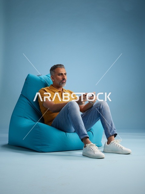 رجل سعودي يلعب ألعاب الفيديو على كرسي بين باق