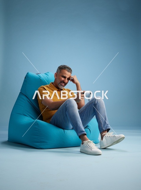 رجل سعودي يلعب ألعاب الفيديو على كرسي بين باق