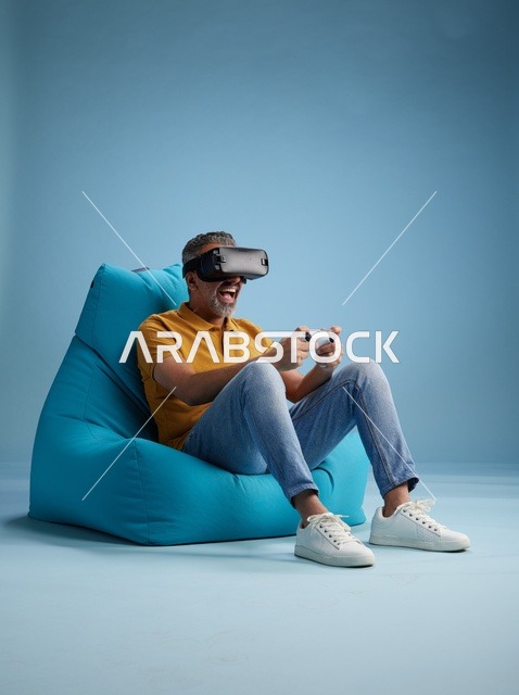 رجل سعودي يلعب ألعاب الواقع الافتراضي على كرسي بين باج