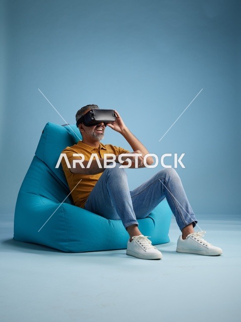 رجل سعودي يستخدم نظارة الواقع الافتراضي على كرسي