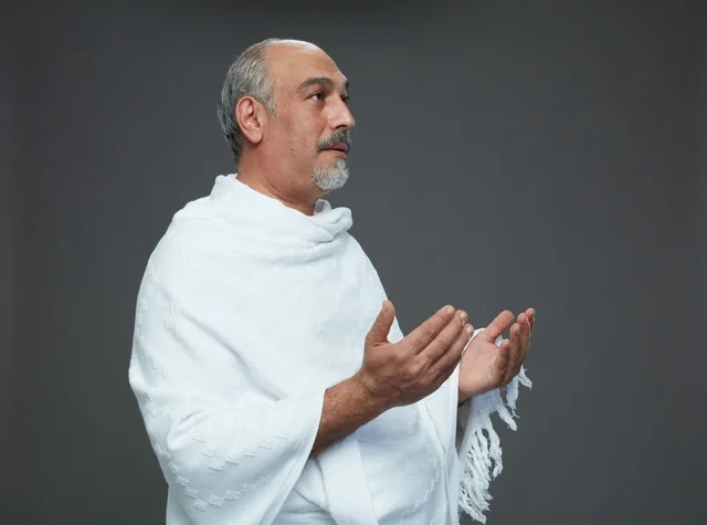 رجل سعودي بملابس الإحرام يدعو أثناء أداء المناسك