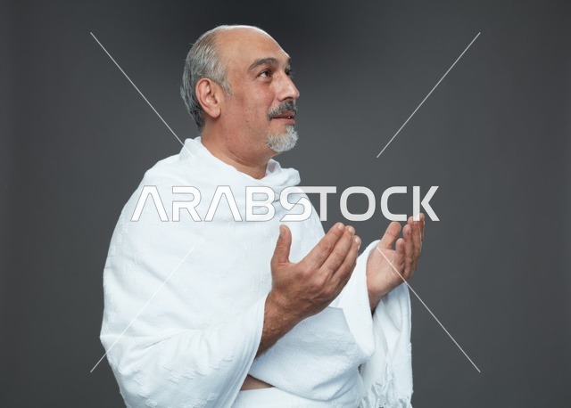 رجل سعودي بملابس الإحرام يدعو أثناء أداء المناسك