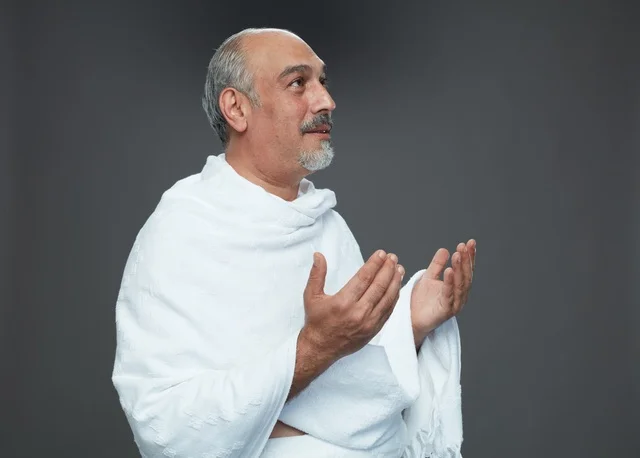 رجل سعودي بملابس الإحرام يدعو أثناء أداء المناسك