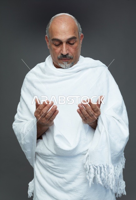 رجل سعودي بملابس الإحرام يدعو أثناء أداء المناسك