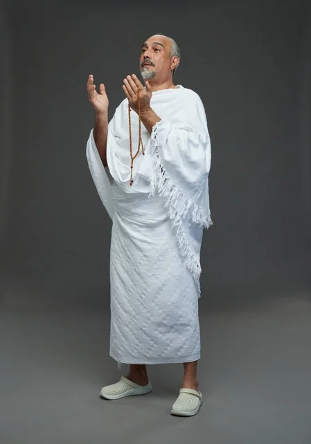 رجل سعودي بملابس الإحرام يدعو أثناء أداء المناسك