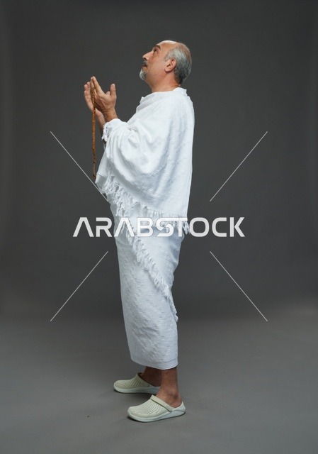 رجل سعودي بملابس الإحرام يدعو في الاستوديو