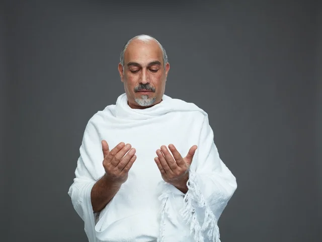 رجل سعودي بملابس الإحرام يدعو في الاستوديو