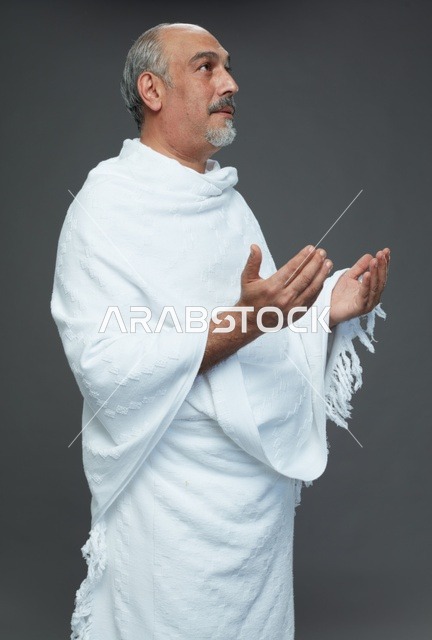 رجل سعودي بملابس الإحرام يدعو في الاستوديو