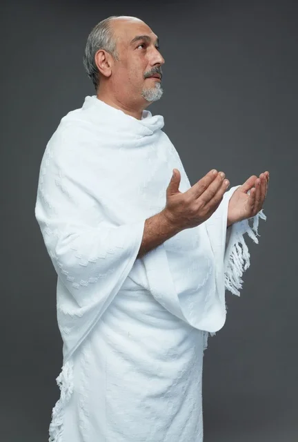 رجل سعودي بملابس الإحرام يدعو في الاستوديو