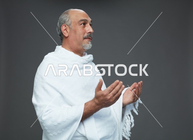 رجل سعودي بملابس الإحرام يدعو أثناء أداء المناسك