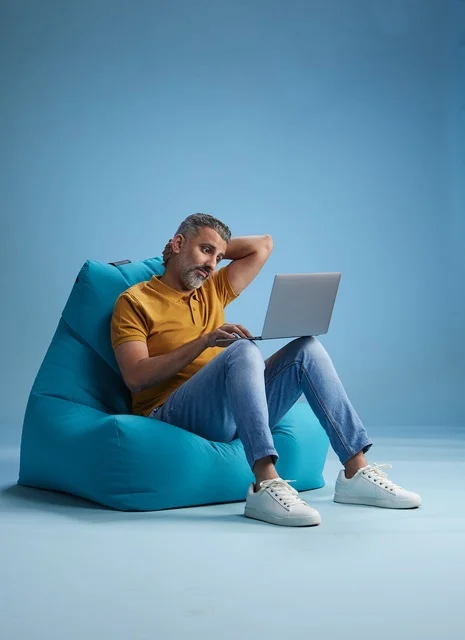 Arab Man Working on Laptop on Bean Bag Chair
