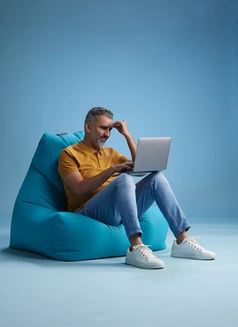 Saudi Man Working on Laptop in Bean Bag Chair