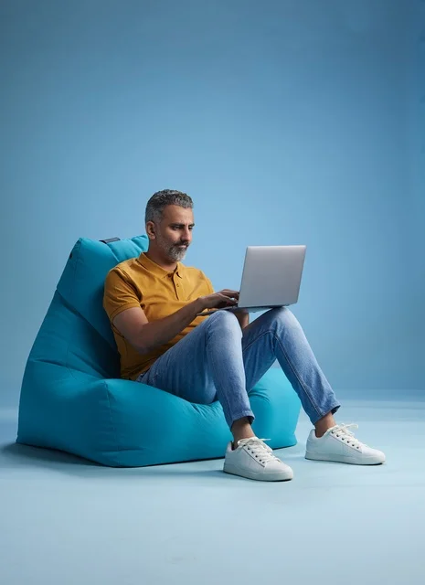 Saudi Man Working on Laptop Sitting on Bean Bag