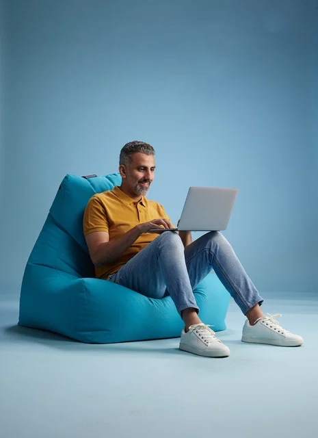 Saudi Man Working on Laptop on Bean Bag Chair