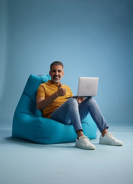 رجل سعودي يستخدم اللابتوب على كرسي بين باق