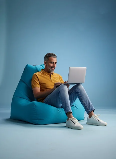 Saudi Man Working on Laptop in Bean Bag Chair