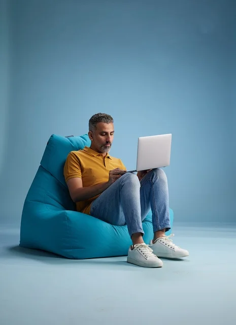 Saudi Man Working on Laptop while Sitting on Bean Bag