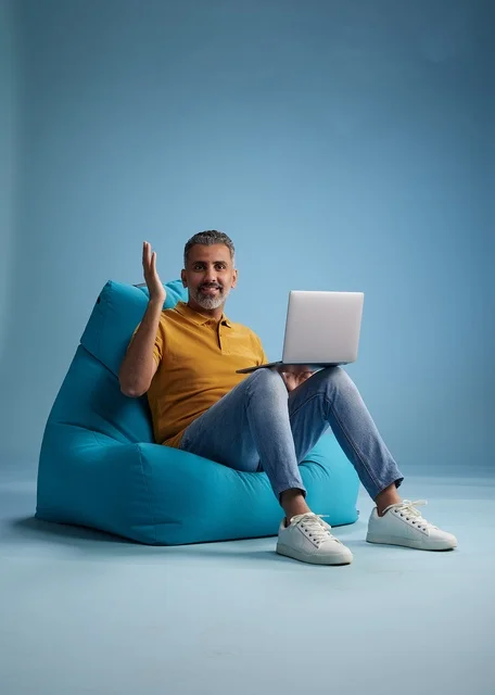 رجل سعودي يستخدم اللابتوب على كرسي بين باق