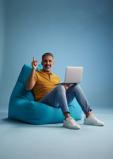 رجل سعودي يستخدم اللابتوب على كرسي بين باج