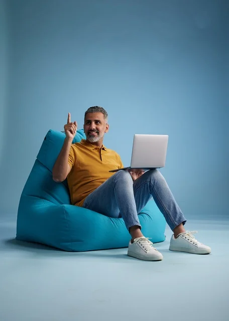 Saudi Man Working on Laptop Sitting on Bean Bag Chair