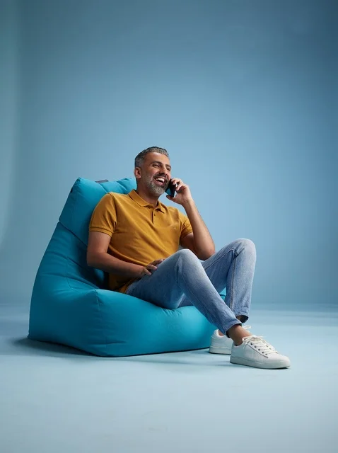 Saudi Man Talking on Phone on Blue Bean Bag