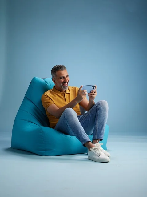 Saudi Man Using Smartphone on Bean Bag Chair