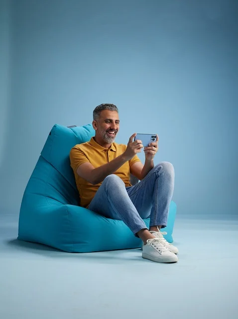 Saudi Man Using Smartphone on Bean Bag Chair