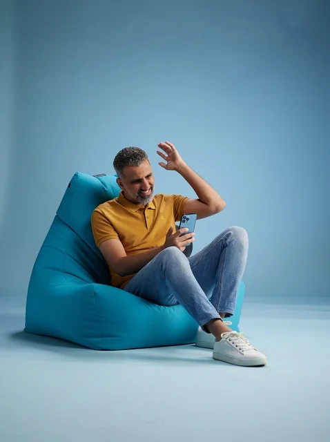 Saudi Man Using Smartphone on Bean Bag Chair in Studio