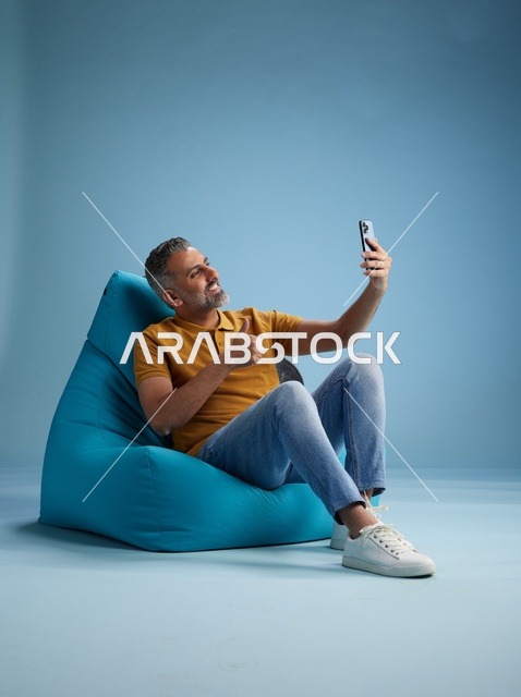 رجل سعودي يلتقط سيلفي على كرسي بين باق