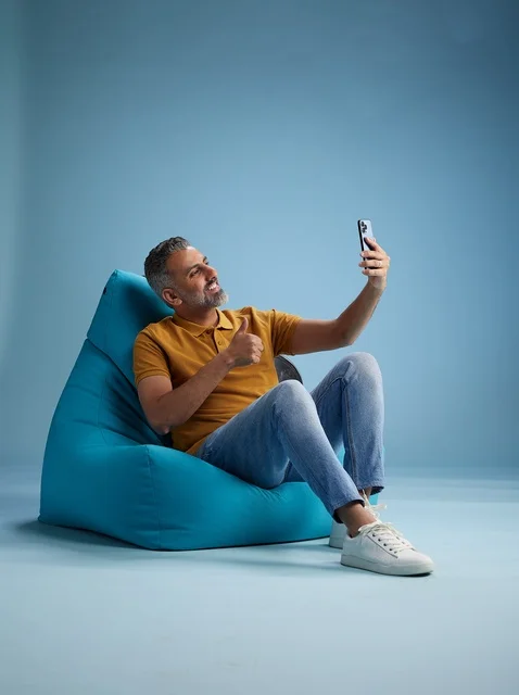 رجل سعودي يلتقط سيلفي على كرسي بين باق