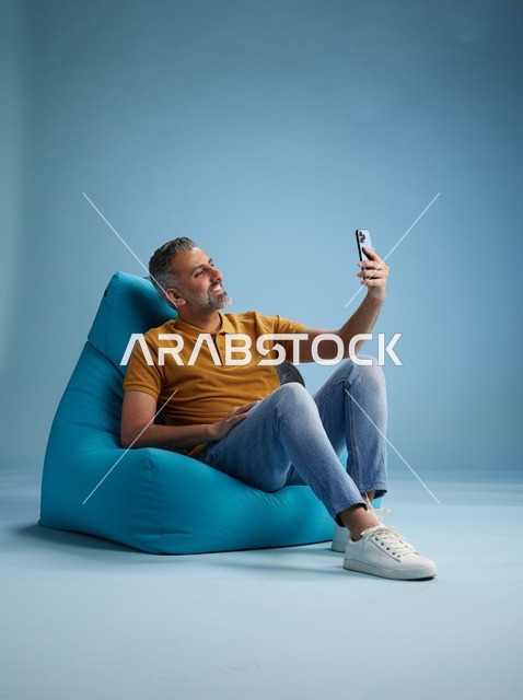 رجل سعودي على كرسي بين باق يلتقط سيلفي