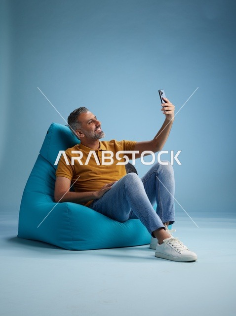 رجل سعودي على كرسي بين باق يلتقط صورة سيلفي