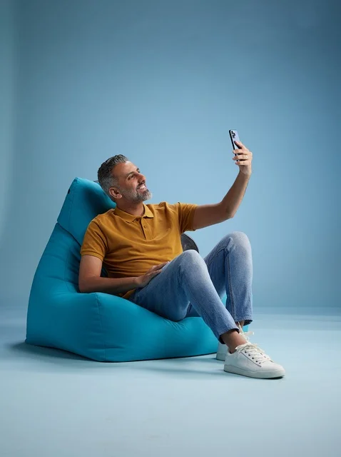 رجل سعودي على كرسي بين باق يلتقط صورة سيلفي