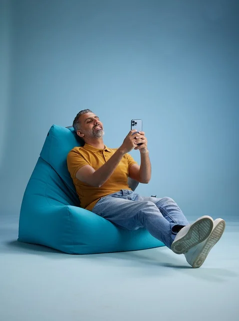 Saudi Man Using Smartphone on Bean Bag Chair in Studio