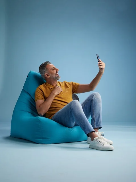 رجل سعودي يلتقط سيلفي على كرسي بين باق