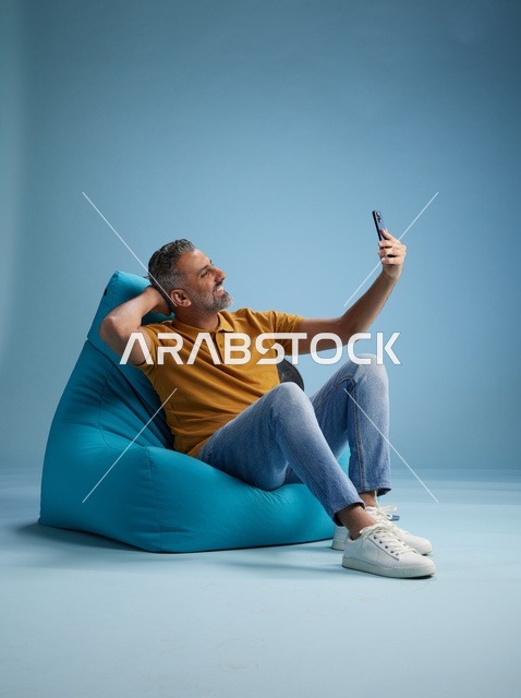 رجل سعودي يلتقط سيلفي على كرسي بين باج