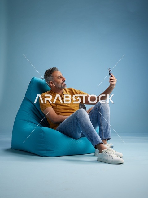 رجل سعودي يلتقط سيلفي على كرسي بين باج