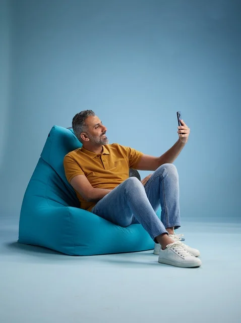 رجل سعودي يلتقط سيلفي على كرسي بين باج