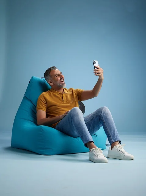 رجل سعودي يلتقط سيلفي على كرسي بين باق