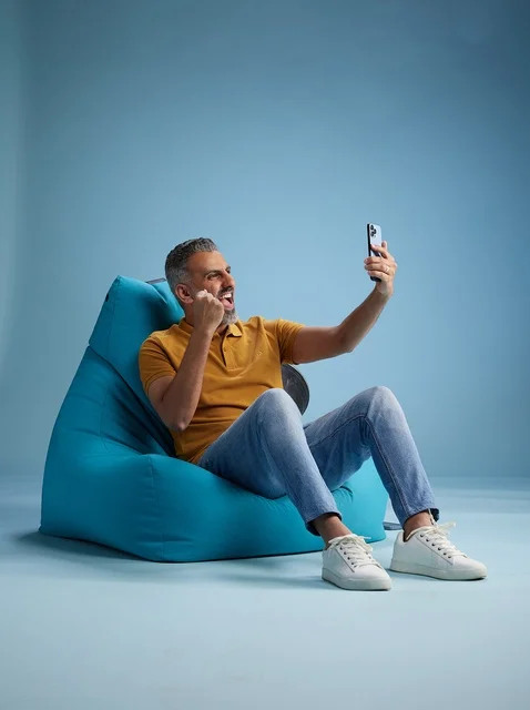 رجل سعودي يلتقط سيلفي بحماس على كرسي بين باج