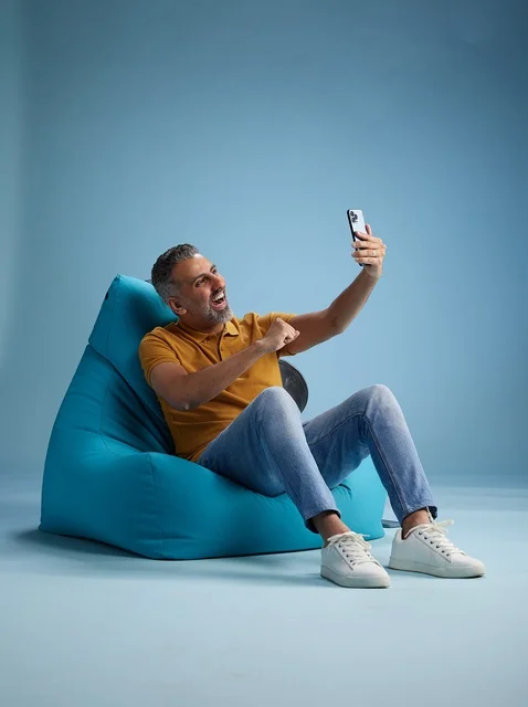 رجل سعودي على كرسي بين باق يلتقط صورة سيلفي