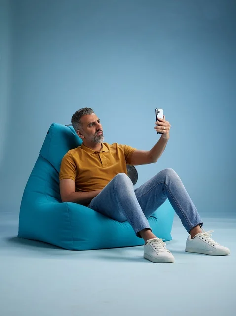 رجل سعودي يجلس على بين باج يلتقط سيلفي