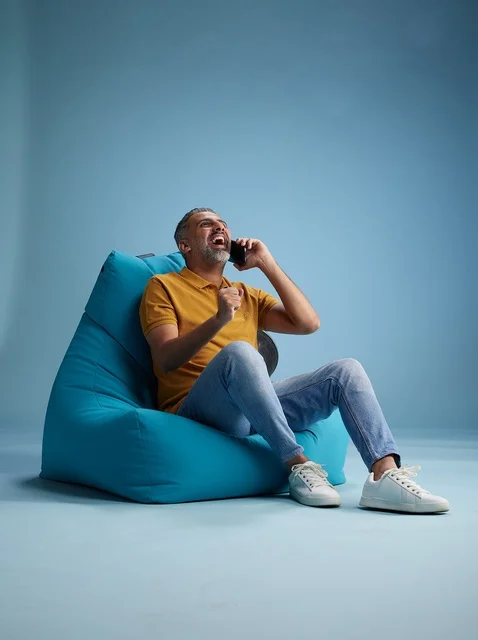 رجل سعودي يتحدث عبر الهاتف جالساً على بين باق