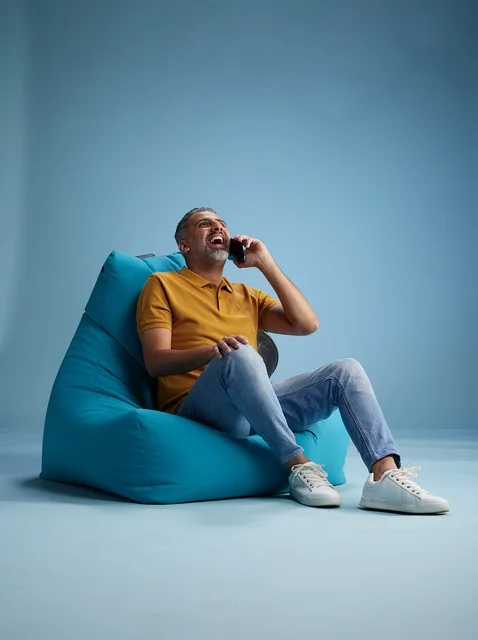 رجل سعودي يتحدث بالهاتف على كرسي بين باج