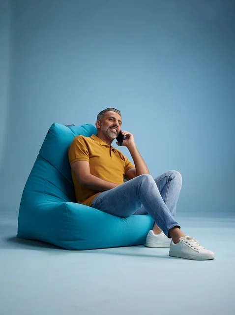 رجل سعودي يتحدث بالهاتف على كرسي بين باج